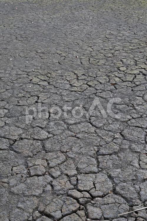 灰色の土の地面が乾燥で割れている様子 灰色,土,地面の写真素材