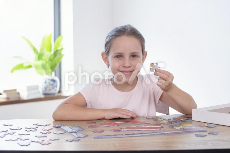 パズルのピースを持ってカメラ目線の女の子2 女の子,パズル,ゲームの写真素材