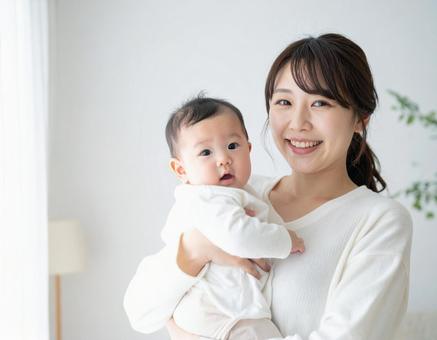 赤ちゃんを抱っこするお母さん 赤ちゃんを抱っこするお母さんの写真