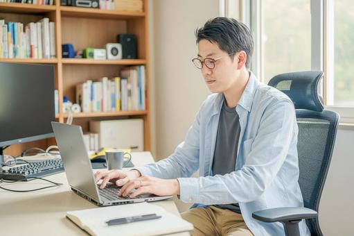 自宅で仕事するかっこいい男性 自宅で仕事するかっこいい男性 仕事,在宅ワーク,テレワークの写真素材