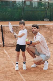 クレイコートで練習する男性と子供の風景 親子,女の子,男性の写真素材