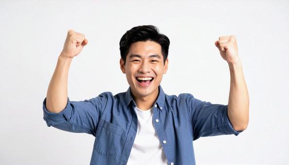 ガッツポーズで笑顔の若いアジア人男性 ガッツポーズで笑顔の若いアジア人男性の写真