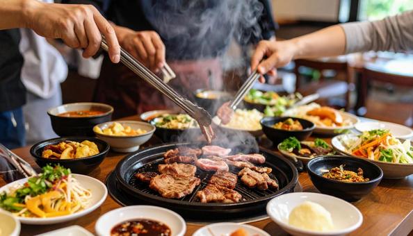 炭火で焼いた美味しそうな焼肉をつまむ 炭火で焼いた美味しそうな焼肉をつまむの写真