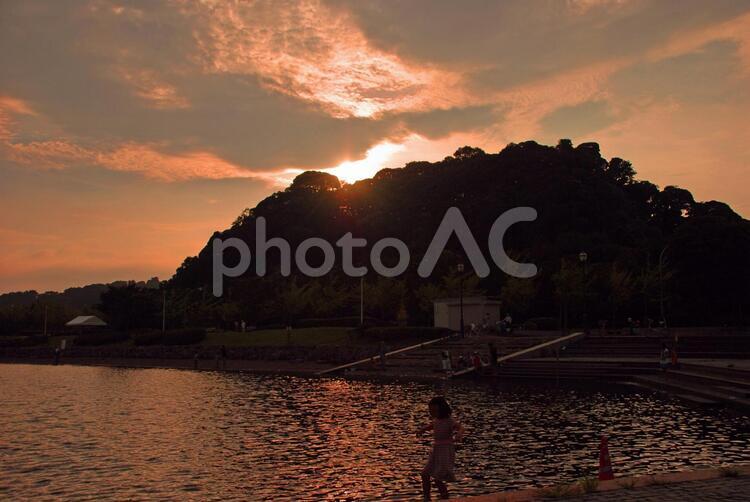 山に沈む 夕日,広場,池の写真素材