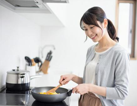 キッチンで料理をする女性 キッチンで料理をする女性の写真