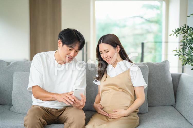 スマホを見る妊婦と男性 妊婦,妊娠,夫婦の写真素材