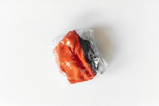 透明なポーチに入ったオレンジと黒の布製品 透明なポーチに入ったオレンジと黒の布製品 モックアップ,物撮り,パッケージの写真素材