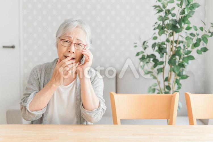 スマホを使う高齢者女性（困る） 迷惑電話,脅迫,オレオレ詐欺の写真素材