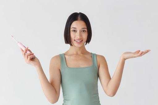 電動歯ブラシを持って両手を横に広げている女性 電動歯ブラシを持って両手を横に広げている女性 111,女性,歯ブラシの写真素材