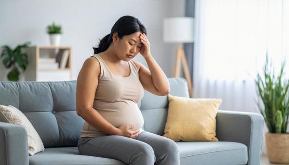 肥満で疲れやすく、額に手をやる女性 肥満で疲れやすく、額に手をやる女性の写真