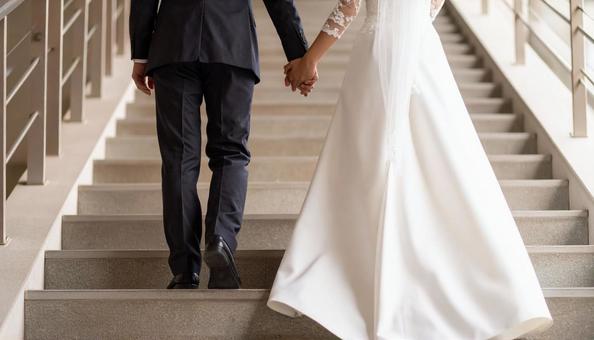 手をつないで階段を上っていく新郎新婦 手をつないで階段を上っていく新郎新婦の写真