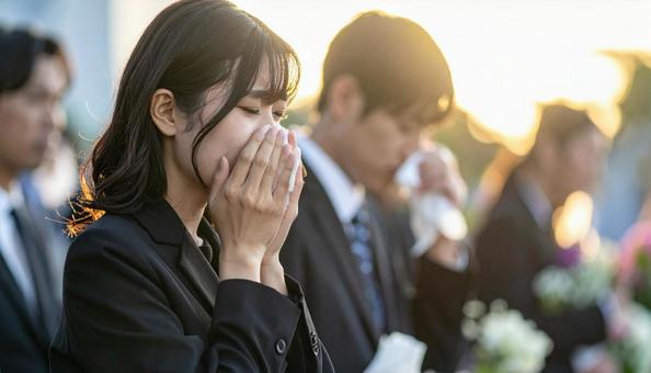 葬儀の時、涙を拭う喪服姿の日本人女性の写真