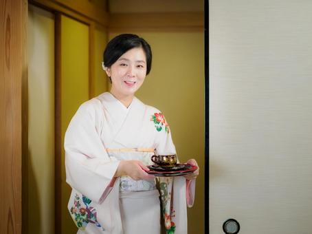 33:お茶をお出しする着物の女性 33:お茶をお出しする着物の女性 着物,おもてなし,お茶だしの写真素材