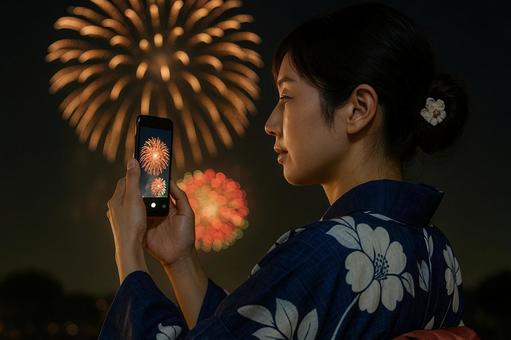 花火を撮影する浴衣の女性 花火を撮影する浴衣の女性の写真
