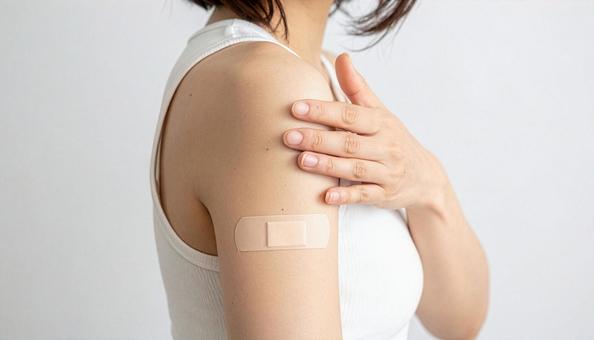 絆創膏を貼った女性の腕のアップ 絆創膏を貼った女性の腕のアップの写真