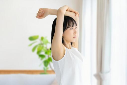 リビングでストレッチをする若い女性 リビングでストレッチをする若い女性 女性,美容,健康の写真素材