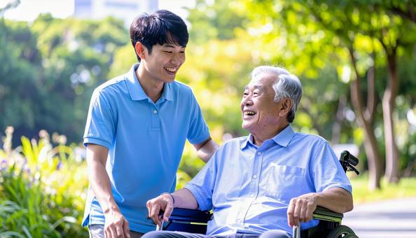 散歩する車椅子の高齢男性と男性介護士 散歩する車椅子の高齢男性と男性介護士の写真