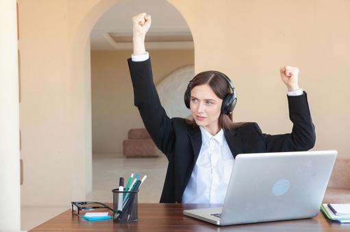 拳をあげ横を見る外国人女性 女性,外国人,ノートパソコンの写真素材