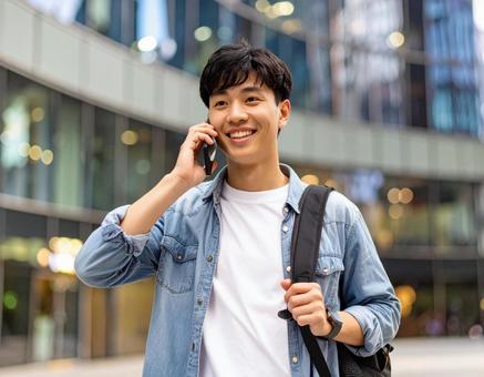 街中で電話をかける男性 街中で電話をかける男性の写真