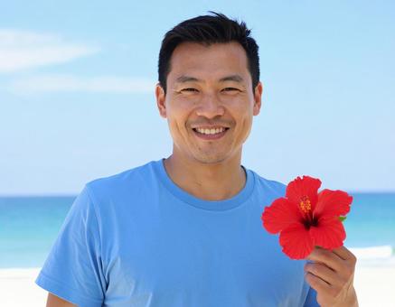 ハイビスカスを差し出す彼・夏のリゾートの写真