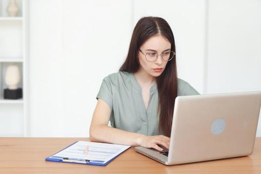 ノートPC使う眼鏡をかけた女性 保険業,事務職,接客業の写真素材