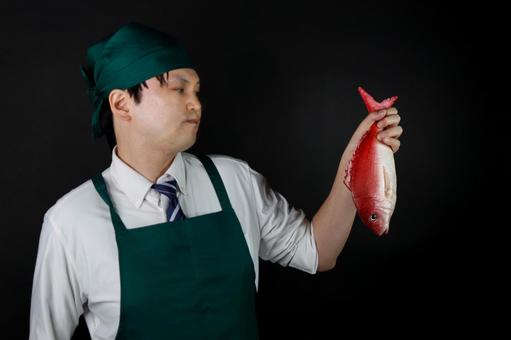 魚を持つ料理人 魚を持つ料理人の写真