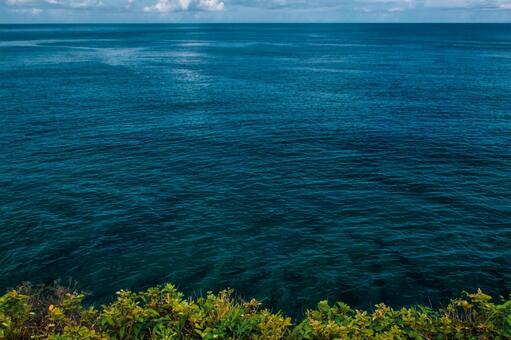 沖縄県国頭郡、見下ろす崖から望む濃紺の海 海,青,水平線の写真素材
