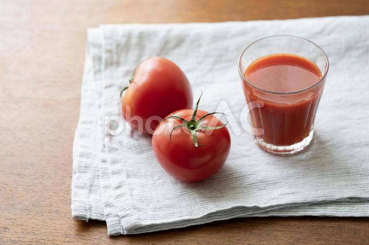 リネンに乗せたトマトジュースとトマト2個 トマトジュース,トマト,野菜の写真素材