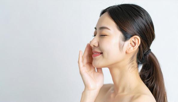 ほほをさわり満足して目をつむる若い女性 ほほをさわり満足して目をつむる若い女性の写真