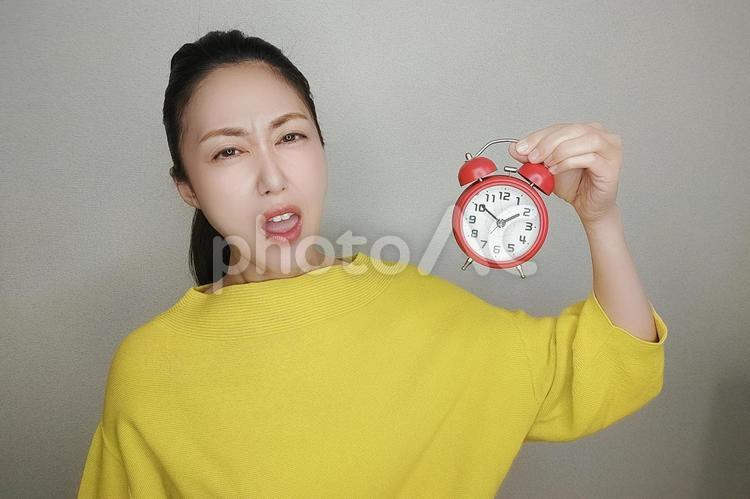目覚まし時計を持つ女性 女性,人物,ビジネスの写真素材