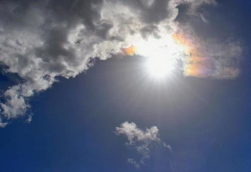 輝く太陽と日暈と雲の写真