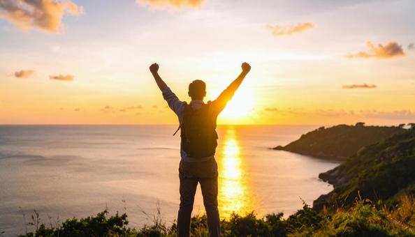 夕焼け空に、両手を広げる男性のシルエット 夕焼け空に、両手を広げる男性のシルエットの写真