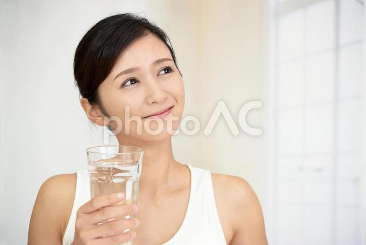 お水の入ったグラスを持つ笑顔の女性 女性,女,笑顔の写真素材