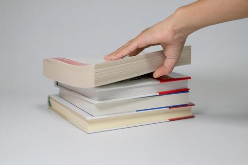 積まれた本と手に触れる動作 本,積まれた本,読書の写真素材