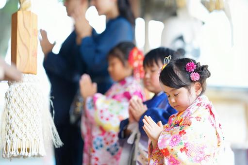 花飾りをつけた着物の少女がお祈りする姿 花飾りをつけた着物の少女がお祈りする姿 七五三,お参り,七五三参りの写真素材