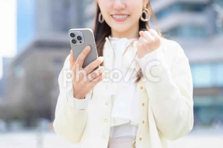 スマホを見てガッツポーズをする女性 日本人,女性,20代の写真素材