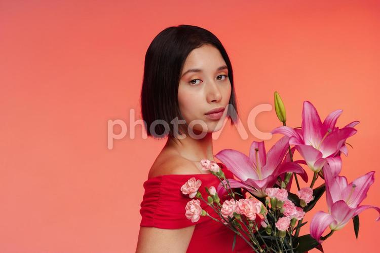 花束を持ちカメラ目線の女性 女性,花,花束の写真素材
