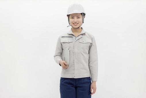 ノートパソコンを持つ作業服の女性 ノートパソコンを持つ作業服の女性 女性,ビジネスウーマン,作業服の写真素材