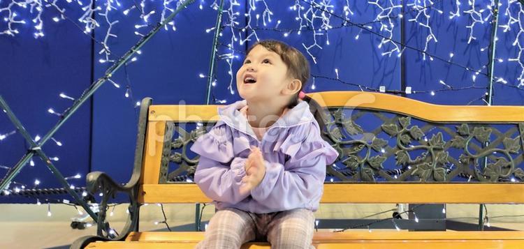 イルミネーションに目を輝かせる女の子 イルミネーション,ベンチ,子供の写真素材