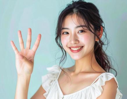 4を指で示す笑顔の女性 4を指で示す笑顔の女性の写真
