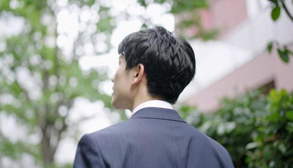 新緑の中で背中を向けて悩むビジネスマン 新緑の中で背中を向けて悩むビジネスマン の写真
