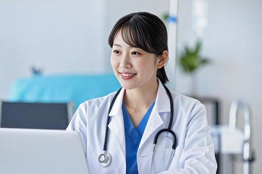 ノートパソコンに向かう、笑顔の女性医師の写真