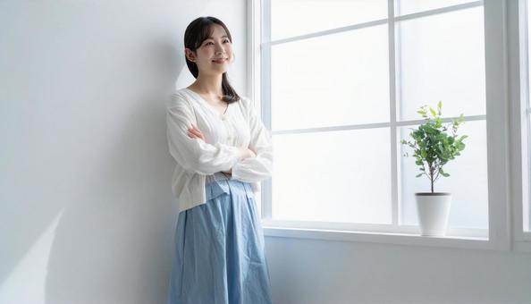 窓際に立つ女性 窓際に立つ女性の写真