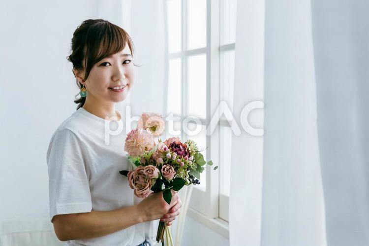プレゼントの花束を持つ日本人女性の横顔 花,花束,プレゼントの写真素材