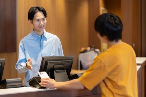 ショッピングをしてモバイル決済をする男性 モバイル決済,ショッピング,買い物の写真素材