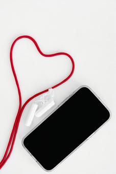 タンポンと紐で作ったハート型と黒い画面のスマートフォン 生理,月経,生理用品の写真素材