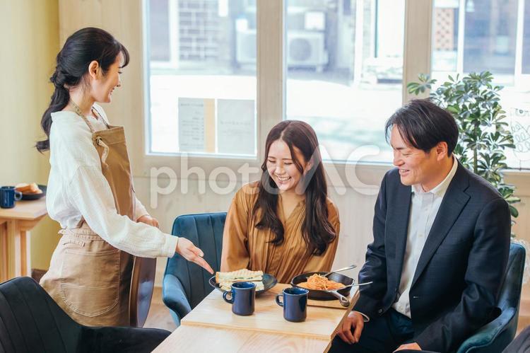 食べ物を運ぶホールスタッフと客 ランチ,カフェ,昼食の写真素材