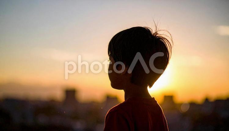 夕焼けの空を見つめる日本人の少年 ビジョン,将来,子供の写真素材