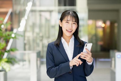スマートフォンを使う若いビジネスウーマン スマートフォンを使う若いビジネスウーマン スマートフォン,スマホ,携帯電話の写真素材