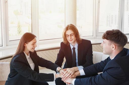 窓際で手を重ねる男女 男女,外国人,ビジネスの写真素材